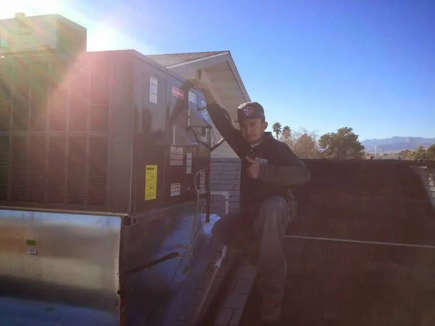 HVAC technician performing Air Duct Cleaning on a rooftop unit in Millersville